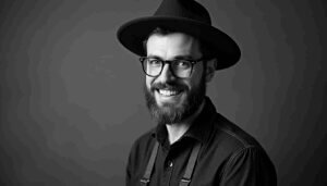 Handwerker mit Hut und Brille, der die NRW Microcrowd in Anspruch nimmt.