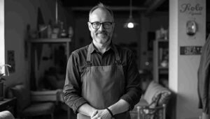 Lächelnder Mann in Schürze, der das NRW Bank Gründung und Wachstum in Anspruch nimmt.