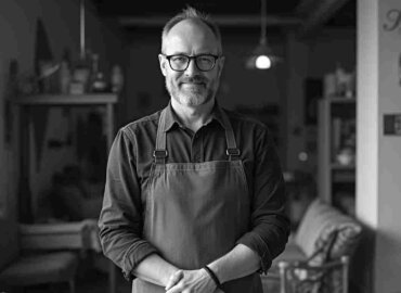 Lächelnder Mann in Schürze, der das NRW Bank Gründung und Wachstum in Anspruch nimmt.