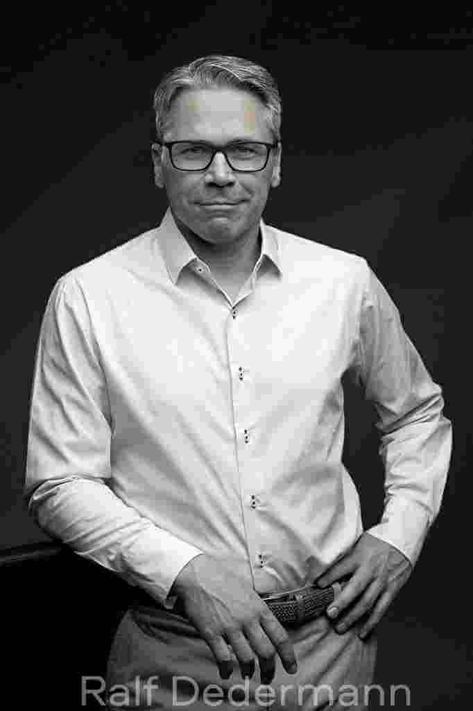 Mann in weißem Hemd, stehend.